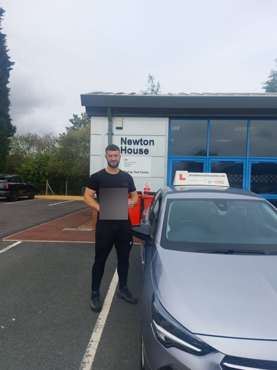 Learner celebrating a recent practical-test pass outside a local test centre