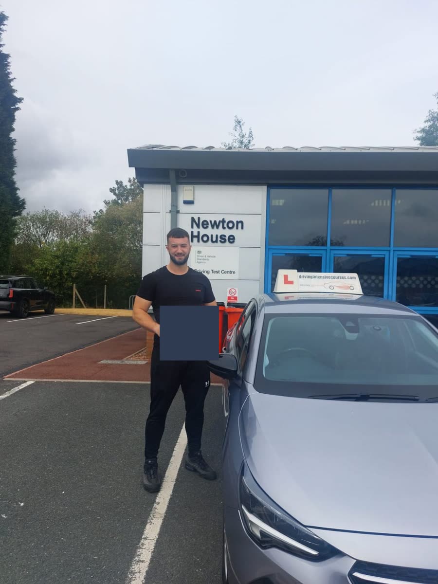 Learner celebrating a practical-test pass beside a Driving Intensive Courses car