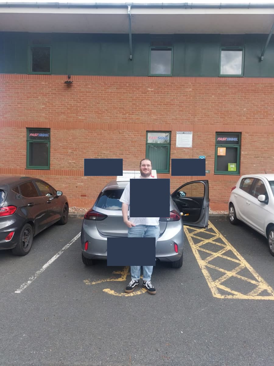 Learner celebrating a practical-test pass beside a Driving Intensive Courses car